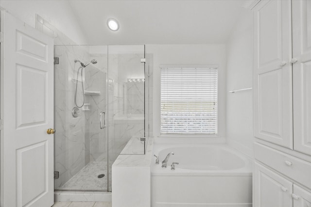 bathroom featuring shower with separate bathtub