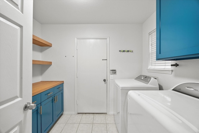 laundry room featuring cabinets, washing machine and dryer, and light tile patterned flooring