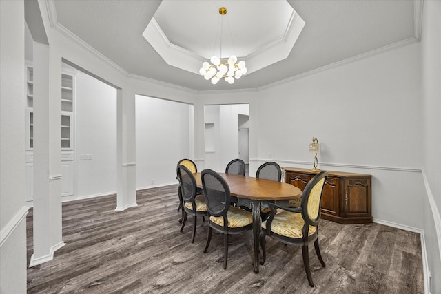 dining area featuring a notable chandelier, dark hardwood / wood-style floors, ornamental molding, and a raised ceiling