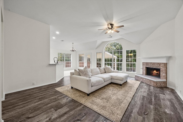 living room featuring sink, dark wood-type flooring, a fireplace, ceiling fan with notable chandelier, and vaulted ceiling