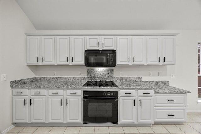 kitchen with white cabinetry, light stone counters, and black appliances