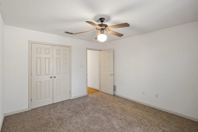 unfurnished bedroom featuring light carpet, ceiling fan, and a closet