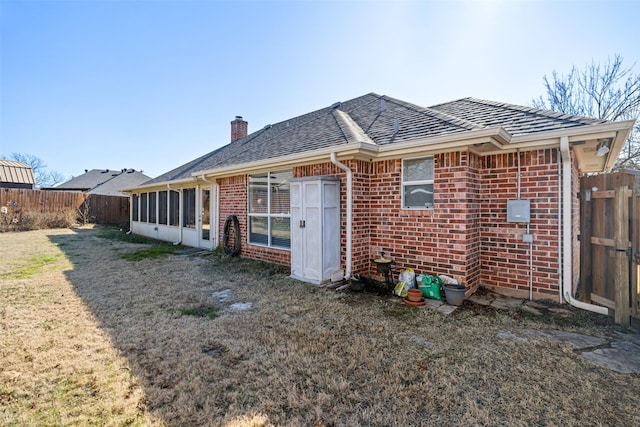 back of property featuring a yard and a sunroom