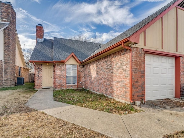 view of front of house with a garage, a front yard, and central AC unit