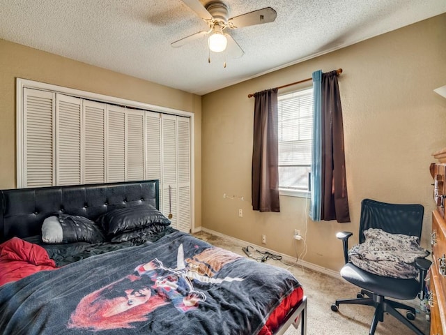 carpeted bedroom featuring ceiling fan, a closet, and a textured ceiling