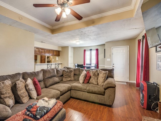 living room featuring hardwood / wood-style flooring, crown molding, and ceiling fan