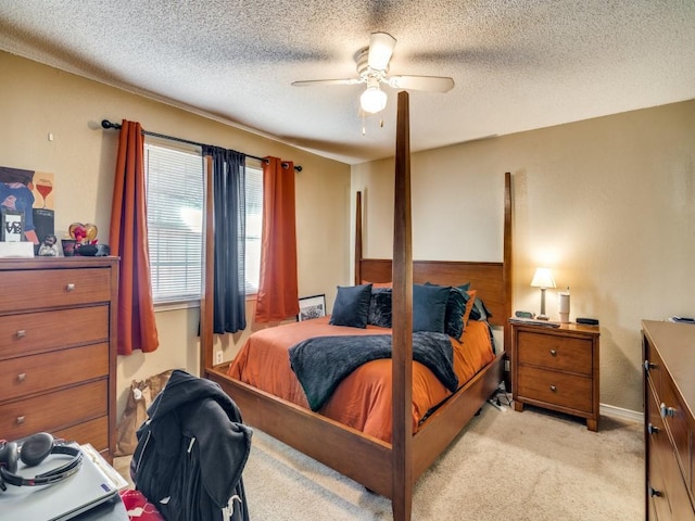 carpeted bedroom with ceiling fan and a textured ceiling