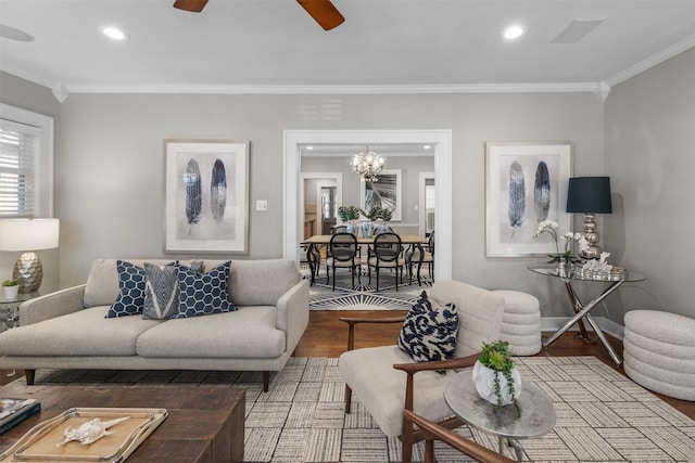 living room with crown molding, wood-type flooring, and ceiling fan with notable chandelier