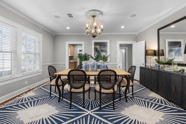 dining area with ornamental molding, light hardwood / wood-style floors, and a notable chandelier