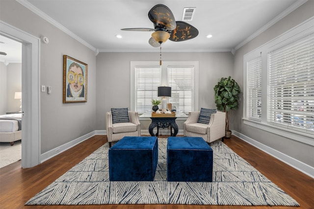 sitting room with dark wood-type flooring, ornamental molding, and ceiling fan