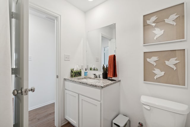 bathroom with vanity, hardwood / wood-style floors, and toilet