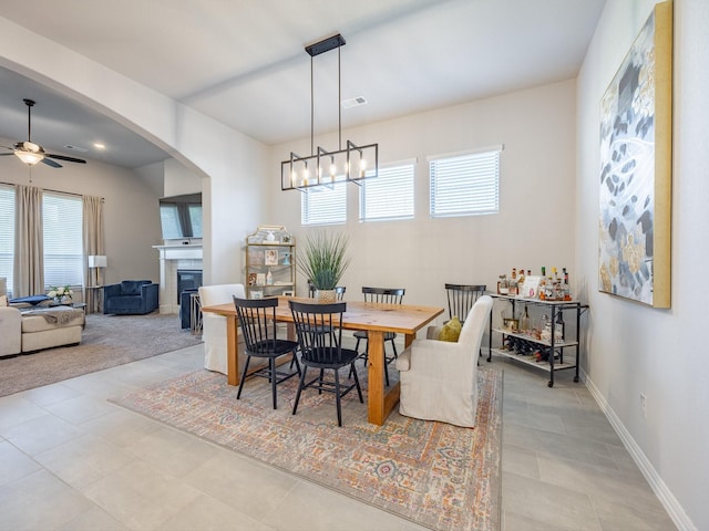 dining space featuring ceiling fan with notable chandelier