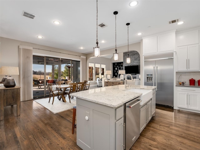 kitchen featuring white cabinetry, appliances with stainless steel finishes, and a kitchen island with sink