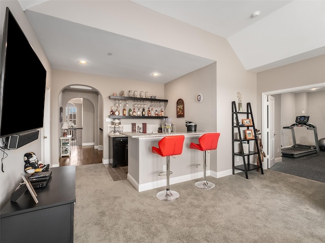 bar with light colored carpet and lofted ceiling