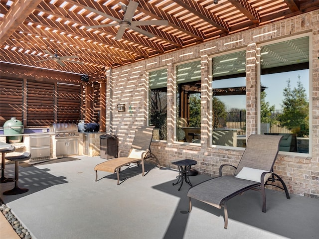 view of patio with exterior kitchen, ceiling fan, and a pergola