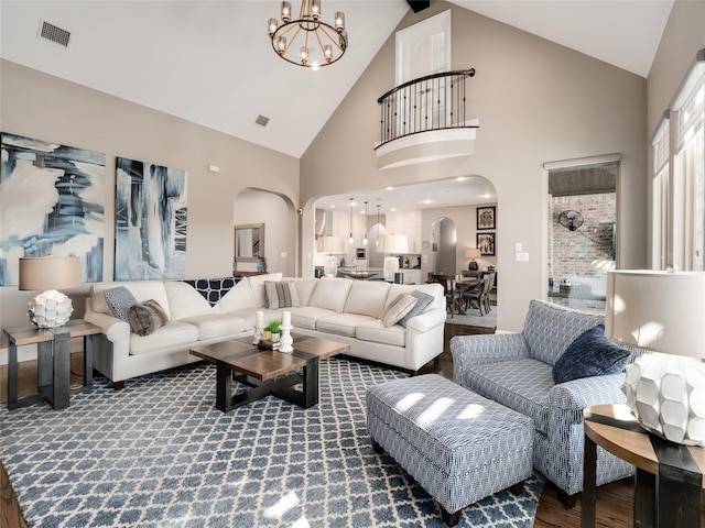 living room with a notable chandelier, hardwood / wood-style floors, and high vaulted ceiling