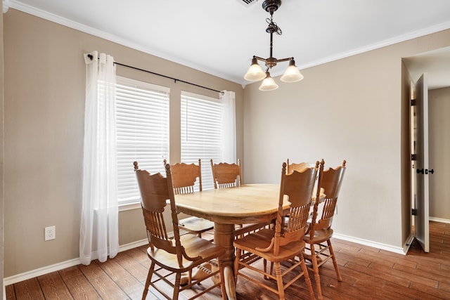 dining room with a notable chandelier, hardwood / wood-style flooring, and ornamental molding