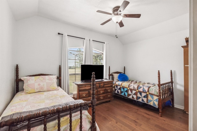 bedroom with dark wood-type flooring, vaulted ceiling, and ceiling fan