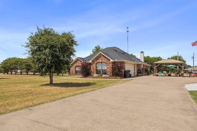 view of front of house with a gazebo, a garage, and a front lawn