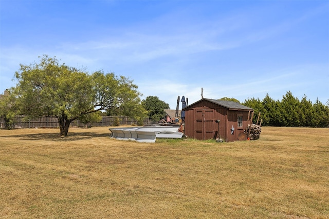 view of yard with a storage unit and a covered pool