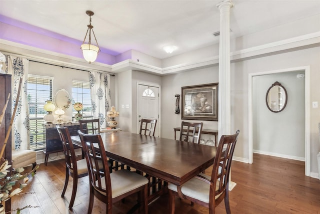 dining area featuring decorative columns and dark hardwood / wood-style floors