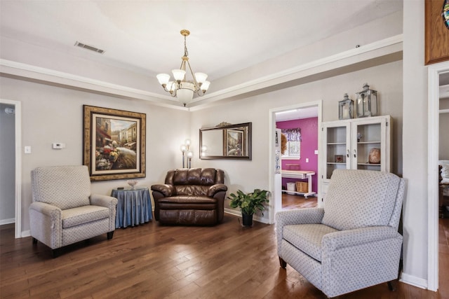 sitting room with dark wood-type flooring and a notable chandelier