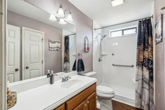 bathroom featuring walk in shower, toilet, wood-type flooring, a textured ceiling, and vanity