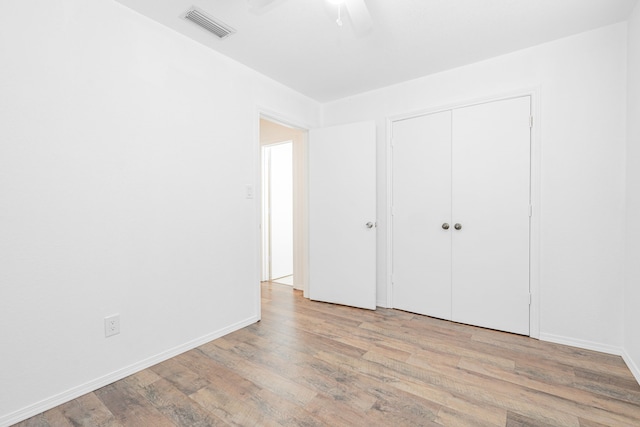 unfurnished bedroom with ceiling fan, a closet, and light wood-type flooring