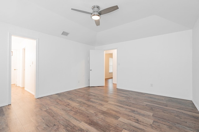 empty room featuring ceiling fan, lofted ceiling, and dark hardwood / wood-style floors