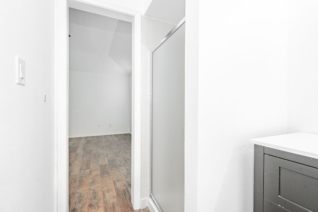 bathroom with an enclosed shower and hardwood / wood-style floors