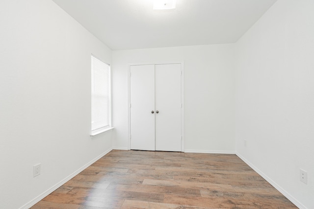 unfurnished bedroom featuring light hardwood / wood-style flooring and a closet