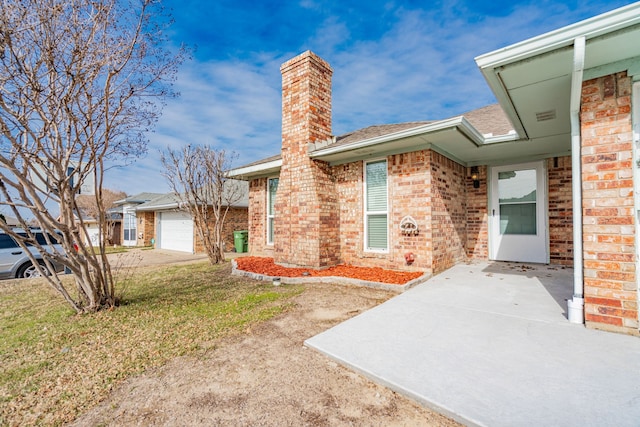 entrance to property with a garage and a lawn