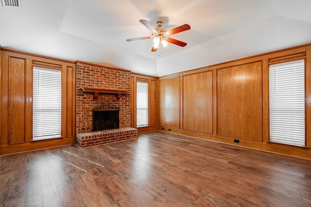 unfurnished living room featuring dark wood-type flooring, ceiling fan, vaulted ceiling, and a brick fireplace