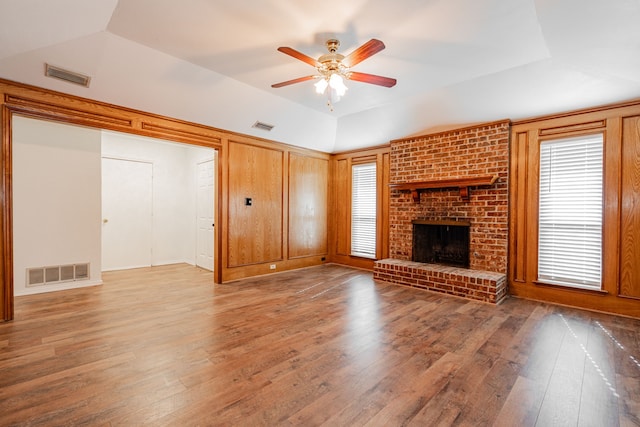 unfurnished living room with vaulted ceiling, hardwood / wood-style floors, ceiling fan, and a fireplace