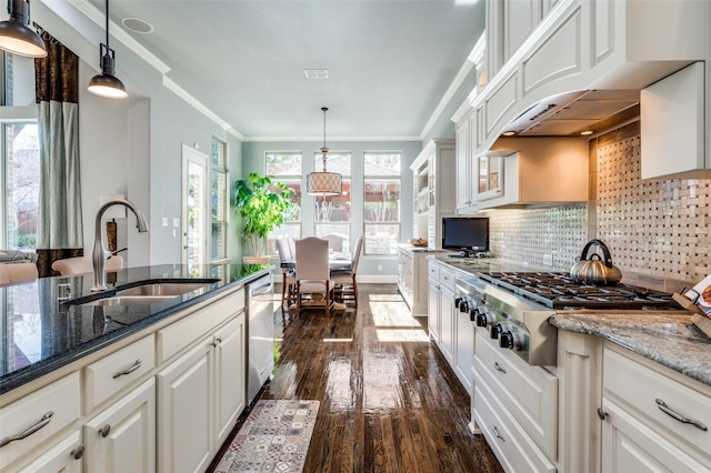 kitchen featuring appliances with stainless steel finishes, sink, white cabinets, backsplash, and dark stone counters