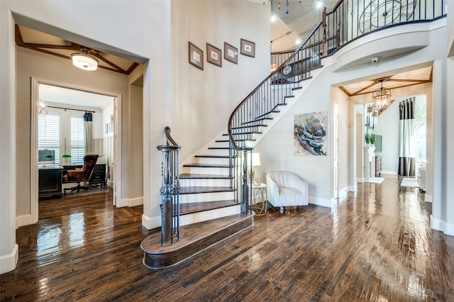 stairway with a towering ceiling and wood-type flooring