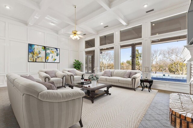 carpeted living area with visible vents, baseboards, ornamental molding, an inviting chandelier, and wallpapered walls