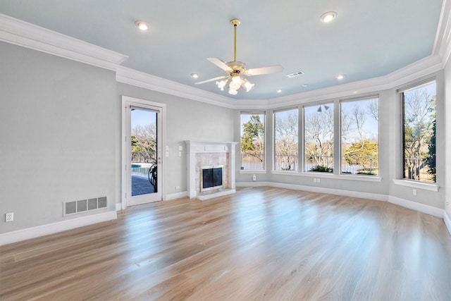 unfurnished living room featuring a healthy amount of sunlight, a premium fireplace, and visible vents