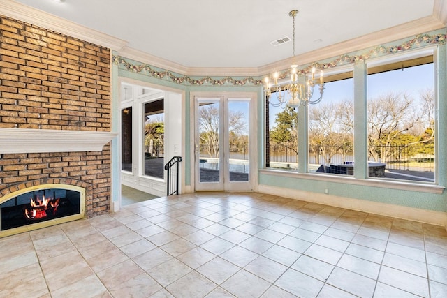 unfurnished dining area featuring a notable chandelier, a fireplace, visible vents, tile patterned floors, and crown molding