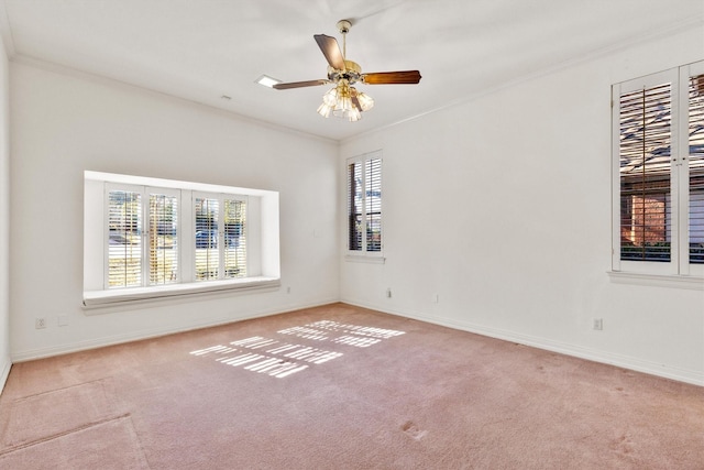 carpeted spare room featuring crown molding and ceiling fan