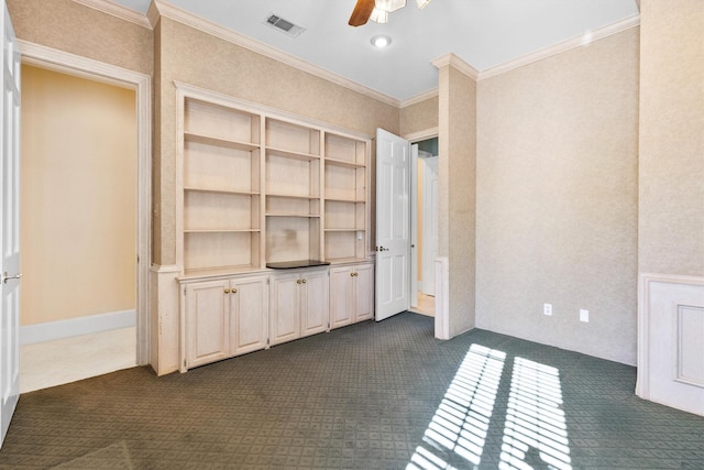 interior space with crown molding, ceiling fan, and dark colored carpet