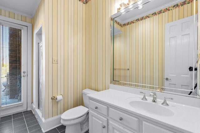 bathroom featuring tile patterned flooring, vanity, toilet, a shower with door, and crown molding