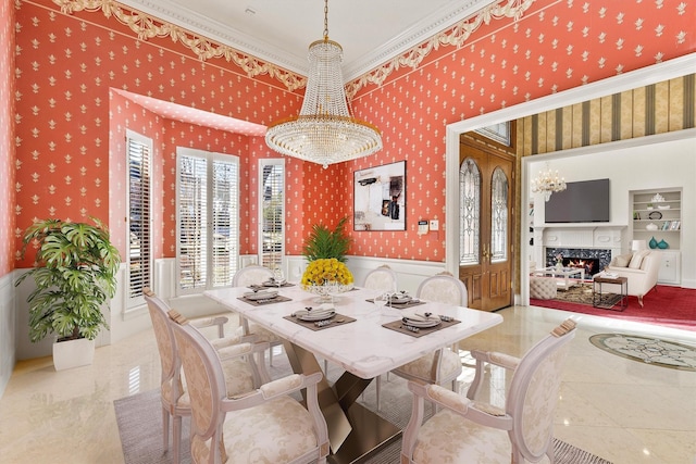 dining area featuring wallpapered walls, built in features, wainscoting, a notable chandelier, and a high end fireplace