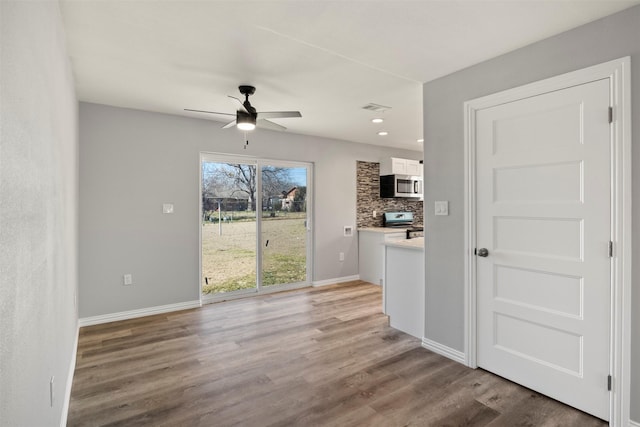 unfurnished dining area featuring hardwood / wood-style floors and ceiling fan