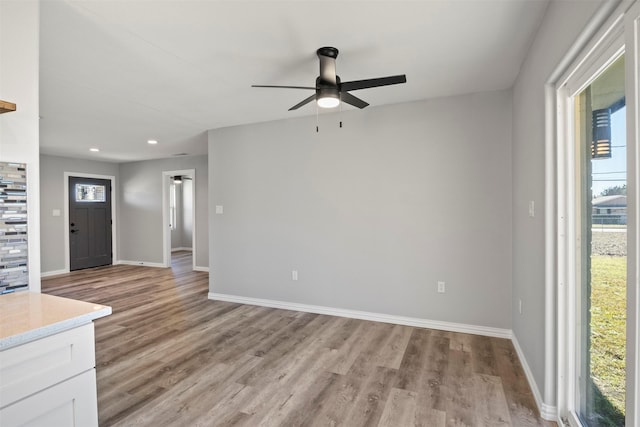 unfurnished living room with a wealth of natural light, light hardwood / wood-style flooring, and ceiling fan