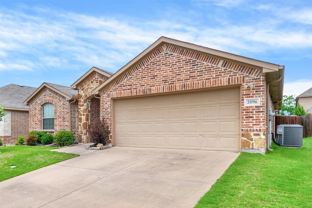 view of front of property featuring a garage, a front yard, and central air condition unit