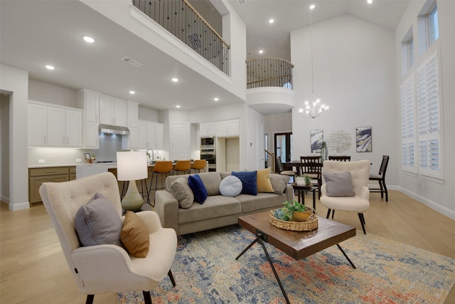 2813 Garrison Dr, Melissa, TX 75454 - living area with a towering ceiling, light wood-style floors, baseboards, recessed lighting, and a chandelier