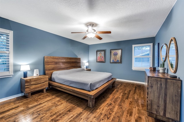 bedroom with ceiling fan, a textured ceiling, and dark hardwood / wood-style flooring