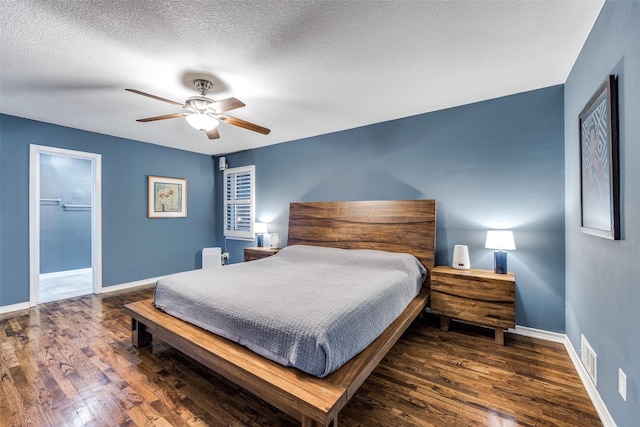 bedroom with ceiling fan, dark hardwood / wood-style floors, and a textured ceiling