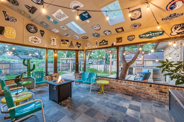 sunroom featuring lofted ceiling with skylight